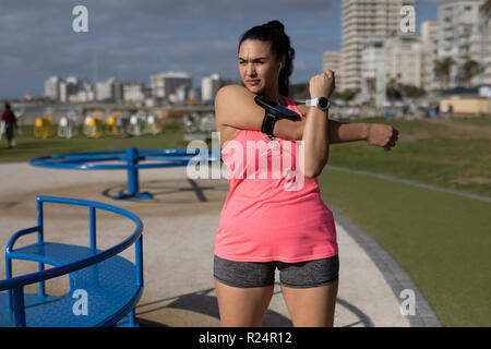 Pareggiatore femmina stretching nel parco Foto Stock