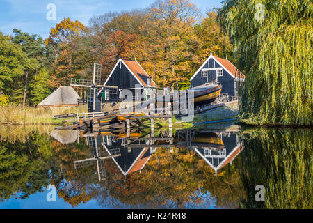 Storica scena olandese con un vecchio cantiere navale, granaio in legno e il mulino a vento di acqua nel museo a cielo aperto in Arnhem nei Paesi Bassi Foto Stock