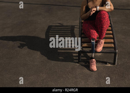 Donna disabile utilizzando smartwatch Foto Stock