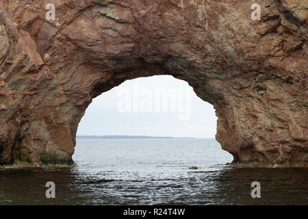 Arco in Perce Rock off il Gaspe Penisola del Quebec, Canada. L'arco è stato creato da fenomeni di erosione da parte delle onde del golfo di St Lawrence. Foto Stock