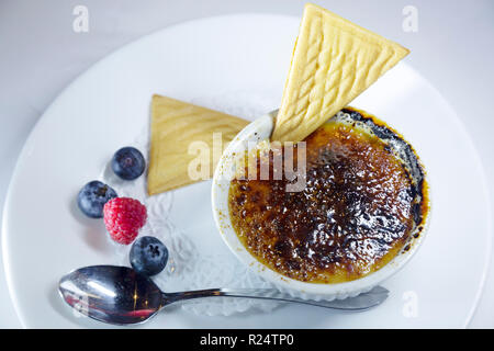 Creme brulee servita con fette di silicio e la frutta di stagione in Quebec, Canada. Il dessert è un disco smalto. Foto Stock