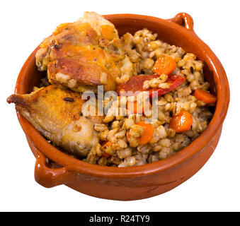 Cotto al forno cosce di pollo con orzo porridge nel recipiente di ceramica. Isolato su sfondo bianco Foto Stock