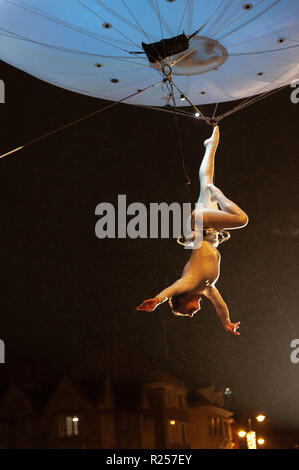 Oxford, Regno Unito. Il 16 novembre 2018. Una femmina di acrobat danze alta sopra la Broad Street, Oxford come parte della città natale della festa delle luci, sospeso sotto un colorato palloncino. Credito: WALvAUS/Alamy Live News Foto Stock