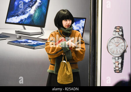 Shinjuku, Tokyo, Giappone. Xvi Nov, 2018. Una ragazza trattiene il suo telefono cellulare davanti a un negozio di elettronica a Shinjuku a Tokyo Giappone il venerdì 16 novembre, 2018. Foto di: Ramiro Agustin Vargas Tabares Credito: Ramiro Agustin Vargas Tabares/ZUMA filo/Alamy Live News Foto Stock