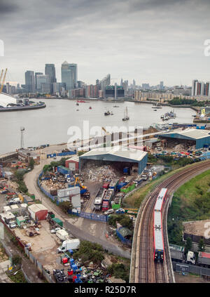 London, England, Regno Unito - 14 Settembre 2013: Un Docklands Light Railway (DLR) treno passa il riciclaggio magazzini su un industrial estate accanto al fiume T Foto Stock