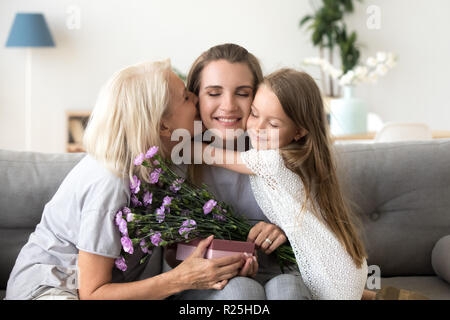 Figlia piccola e vecchia madre baciare abbracciando le congratulazioni Foto Stock