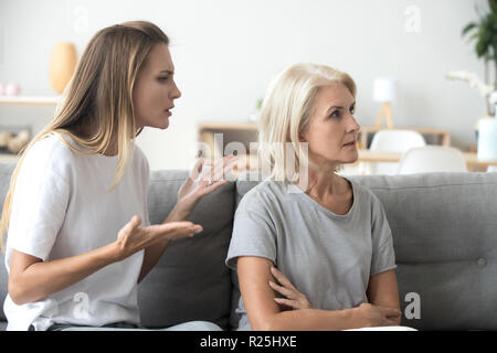 Infastiditi figlia adulta sostenendo con caparbia vecchia madre ignorando Foto Stock