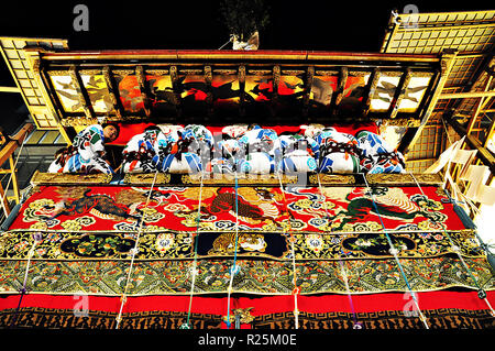 KYOTO, Giappone: un altamente decorato galleggiante lungo con i suoi disegni di uomini in tradizionali abiti Giapponesi in una sfilata durante il Gion Matsuri di luglio, 15 Foto Stock