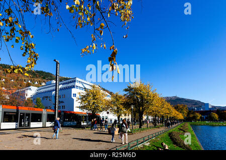 Luce treno Bybanen in Kaigaten, Byparken, nel centro di Bergen, Norvegia. Colori dell'autunno. Mount Ulriken in background Foto Stock