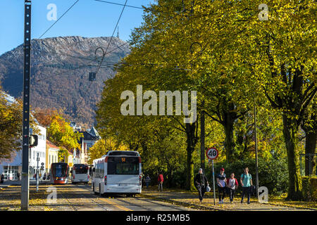 Luce Bybanen di treno e autobus locali in Byparken, nel centro di Bergen, Norvegia. Mount Ulriken in background. Colori dell'autunno Foto Stock