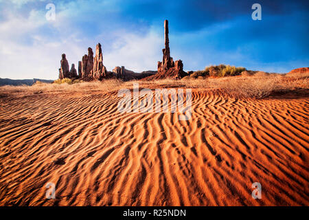 Le dune di sabbia si accumulano intorno alla base del Totem Pole in Monument Valley, Arizona/Utah. Foto Stock