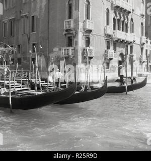 Degli anni Cinquanta, vista storica di Venezia, la celebre città italiana di piccole isole o di zone lagunari separati da canali nel paese del nord del Veneto. Emozionante e romantico, la città è piena di chiese storiche, palazzi antichi ponti e monumenti e naturalmente la famosa gondole, il tradizionale, fondo piatto veneziano barche a remi visto qui. Foto Stock