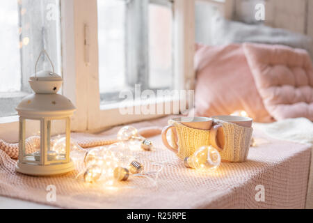 Maglia tazze di lana su un tavolo di legno. due tazze di caffè caldo. il concetto di calore. vacanze ed eventi. In autunno e in inverno, concetto di piacere. Accogliente e confortevole e morbido. Foto Stock