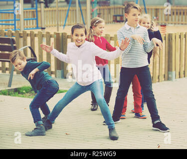 Deliberando gioco con felice allegro ai bambini di prestazioni all'aperto in autunno Foto Stock