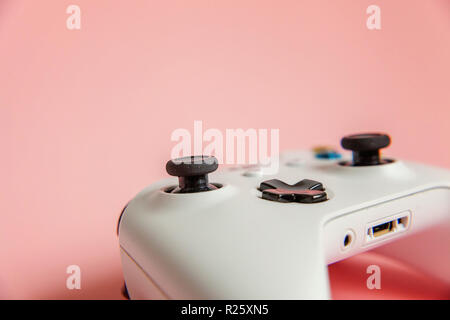 Bianco gamepad joystick, game console sul rosa colorato moderno e alla moda fashion pin-up dello sfondo. Computer gaming concorrenza controllo videogioco affrontare Foto Stock