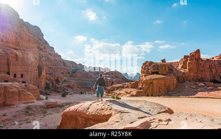 Tourist guarda a rocce scolpite case, Nabataean città di Petra, vicino a Wadi Musa, Giordania Foto Stock