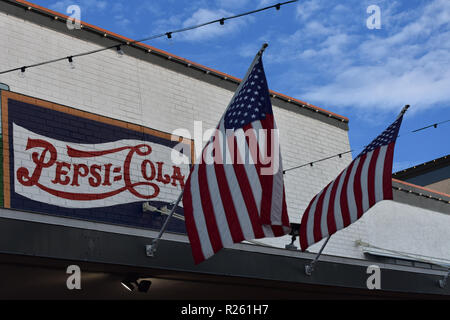 Orlando, Florida. Ottobre 25, 2018. Vista superiore della Pepsi-cola segno vintage e usa le bandiere a Kissimmee Old Town. Foto Stock