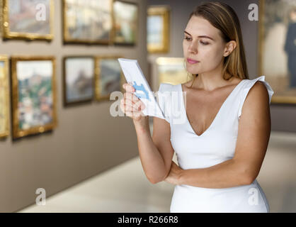 Giovani femmine visitatore di ammirare le opere in esposizione di dipinti nel museo Foto Stock