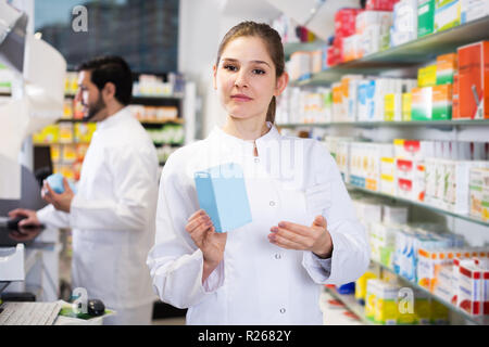 Fiducioso donna il farmacista è in piedi con le medicine in farmacia Foto Stock