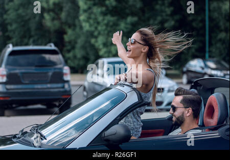 Felice giovane donna godendo di un giro in auto convertibili Foto Stock