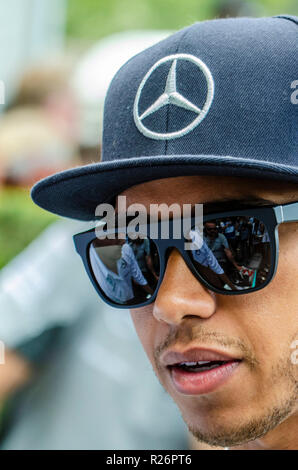 Lewis Hamilton, Mercedes Formula 1 Grand Prix racing driver. Campione del Mondo F1 Racing motor driver in Mercedes cappuccio, hat. Occhiali da sole la riflessione Foto Stock