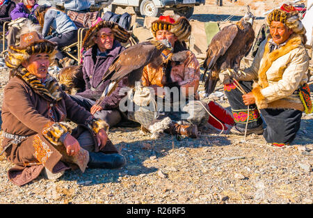 ULGII, MONGOLIA - Ottobre 6, 2018 : Golden Eagle Festival. Il kazako eagle cacciatori in abbigliamento tradizionale sabato sul pavimento in attesa del concorso di UL Foto Stock