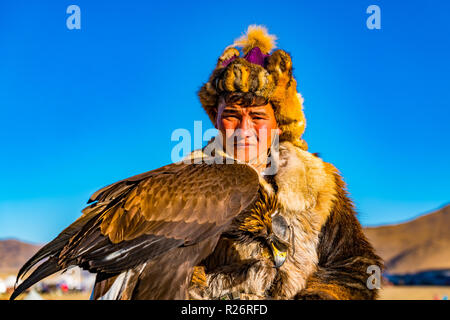 ULGII, MONGOLIA - Ottobre 6, 2018 : Golden Eagle Festival. Il mongolo Golden Eagle Hunter in abbigliamento tradizionale di pelliccia di volpe con eagle sulla sua mano in Foto Stock