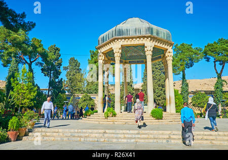 SHIRAZ, Iran, 13 ottobre 2017: i visitatori della tomba di Hafez a piedi in scenic Mussala giardini, godendo questo luogo tranquillo, la sua architettura e la sua landscap Foto Stock