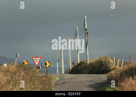 Scena stradale con pali del telegrafo Atlantica selvaggia modo, County Kerry, Irlanda Foto Stock