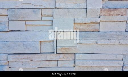 Un muro fatto di pietra ardesia che mostra una superficie ruvida e texture interessanti. Foto Stock