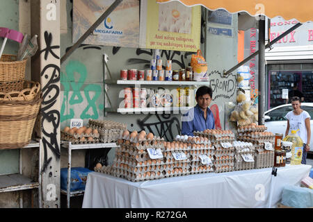 ATHENS, Grecia - 29 agosto 2018: uomo vendita di uova fresche di miele e olio d'oliva alla strada di stallo del mercato nel centro di Atene. Foto Stock