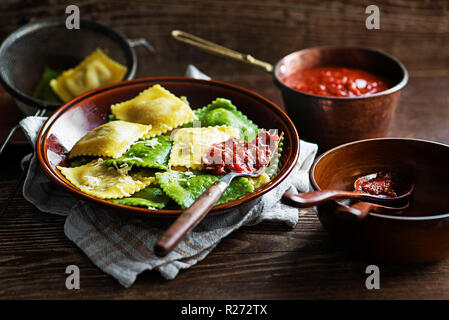 Ravioli di pasta conditi con pomodoro e formaggio parmigiano Foto Stock