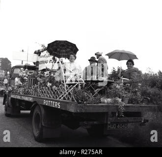 1967, decorato di un galleggiante per la Thame e di Quartiere Garden Club, in un paese di campagna parade, persone sedersi sul sulla parte posteriore di un camion circondato da piante, per promuovere l'area locale del club di giardinaggio, Oxfordshire, Inghilterra, Regno Unito. Foto Stock