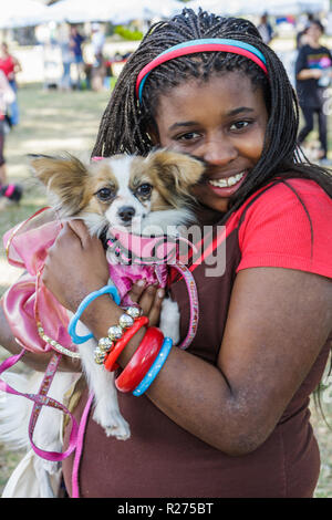 Miami Florida, Legion Park, cani sul passerella, cane, lusso, ben vestito, ragazze ragazza nera, giovane, femmina bambini animali domestici, cane giocattolo, papillon, abbraccio, grovigli Foto Stock