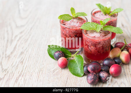 Fresche biologiche carissa carandas succo su sfondo di legno con frutta fresca Foto Stock