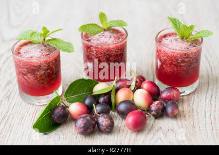 Fresche biologiche carissa carandas succo su sfondo di legno con frutta fresca Foto Stock