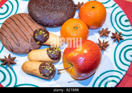 Disposizione di Natale sulla piastra con pan di zenzero, frutta e biscotti Foto Stock