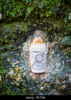 Un vecchio Lynrock zenzero bottiglia di birra insieme in una parete in occidente Lyn River Valley a Lynmouth, Exmoor, DEVON REGNO UNITO sul sito di un antico minerale fattore di acqua Foto Stock