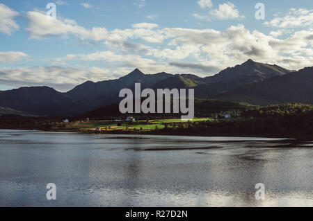 Case e montagne vicino Holmstad, Isole Lofoten in Norvegia Foto Stock