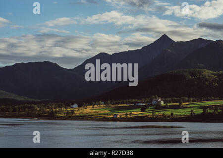 Case e montagne vicino Holmstad, Isole Lofoten in Norvegia Foto Stock