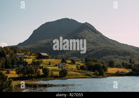 Case e montagne vicino Holmstad, Isole Lofoten in Norvegia Foto Stock