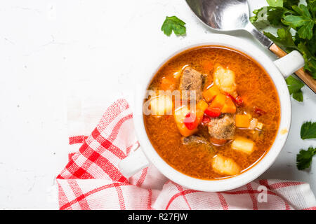 Zuppa di gulasch su bianco tavolo in pietra vista dall'alto. Foto Stock