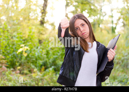 La donna o giovane europeo Caucasian college ragazza o triste studente con cartella e gesto negativo con la sua mano ha sospeso tutti gli esami in università Foto Stock