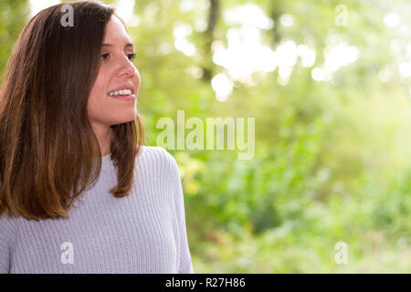 Caucasian europeo del giovane donna o ragazza in natura o la tranquilla foresta guardando gli alberi con gesto di pace e calma perché lei è felice Foto Stock