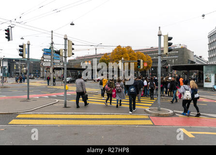 Lucerna, LU / Svizzera - 9 Novembre 2018: molti pedoni folla un incrocio isola in una strada trafficata e crosswalk durante le ore di punta in Lucerna ho Foto Stock