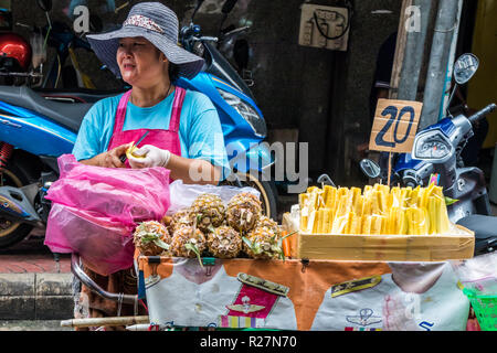 Bangkok, Tailandia - 6 Ottobre 2018: un venditore ambulante vendita di ananas. Ci sono ancora molti mobili di venditori ambulanti in città. Foto Stock