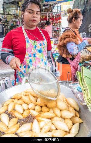 Bangkok, Tailandia - 6 Ottobre 2018: Ladyboy frittura polpette di pesce su un venditore ambulante in stallo. Ci sono ancora molti mobili di venditori ambulanti in città. Foto Stock