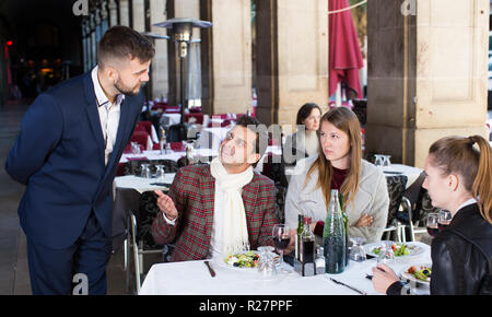 Orinato clienti arrabbiati al ristorante seduti al tavolo a parlare con l'amministratore Foto Stock