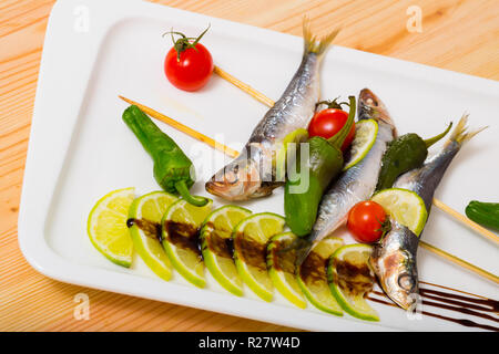 Lo spratto alla griglia con verdure fresche, servita con calce e pasta di aceto balsamico Foto Stock