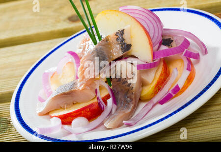 Fette di dolce-cured aringa con patate fritte e cipolle servito sulla piastra Foto Stock